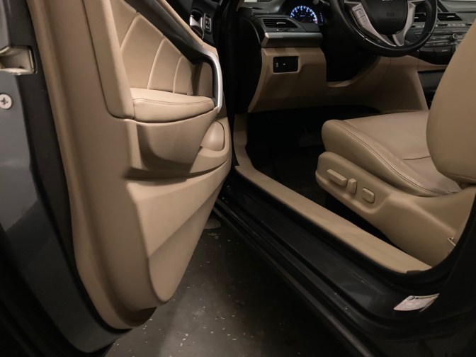 View of interior of 2012 Honda Accord coupe, with focus on front seat, open front driver's side door, and dashboard.