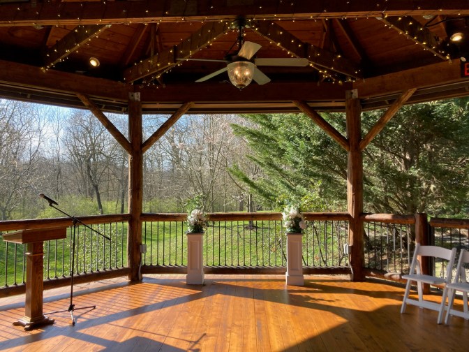 Altar and decorations at front of pavilion, with a view of surrounding woods.
