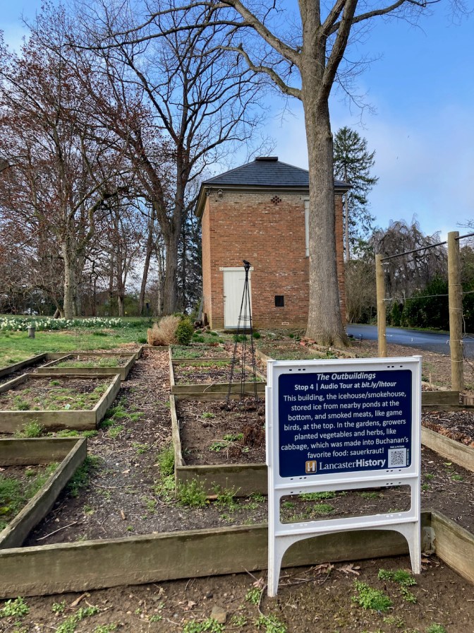 Exterior of icehouse/smokehouse, with small garden in front of it.