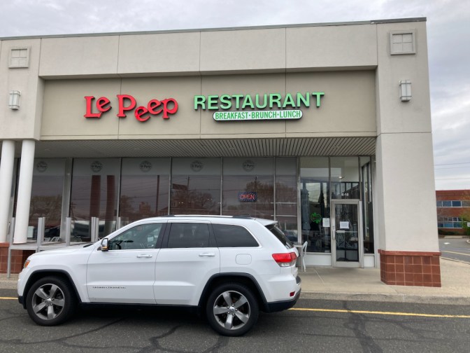 2014 Jeep Grand Cherokee parked in front of Le Peep Restaurant.
