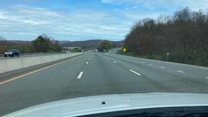 View of I-87 on a partly cloudy day, with mountains in background.