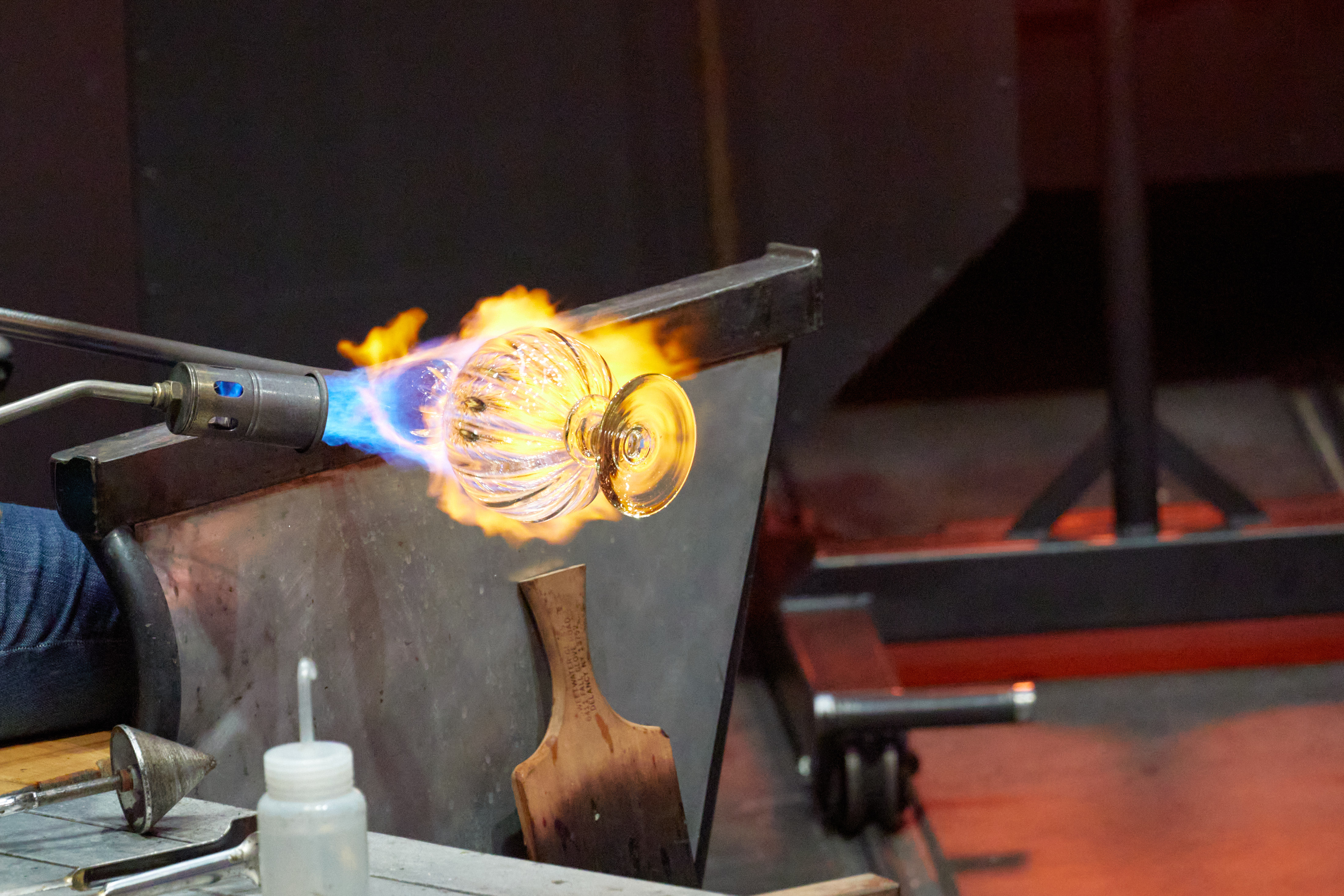 Glass vase being blown in hot shop.