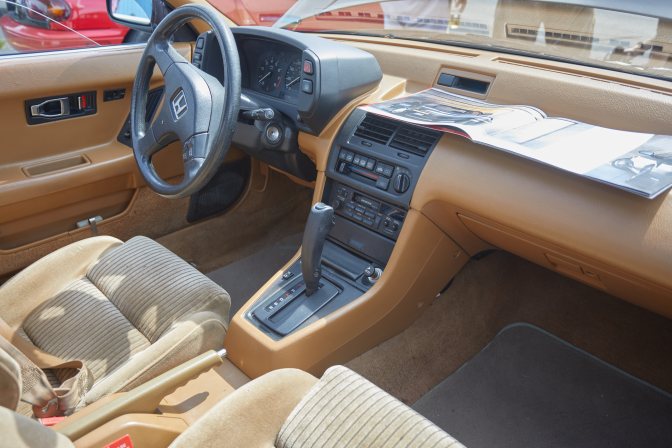 Honda Prelude interior, with dealership brochure on dashboard.