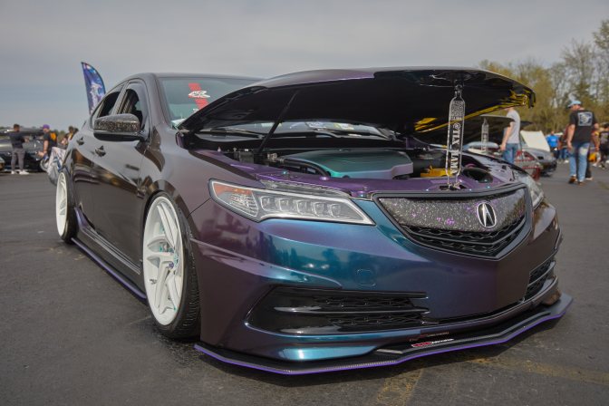 Acura TLX, lowered, with large wheels. It's hood is open.