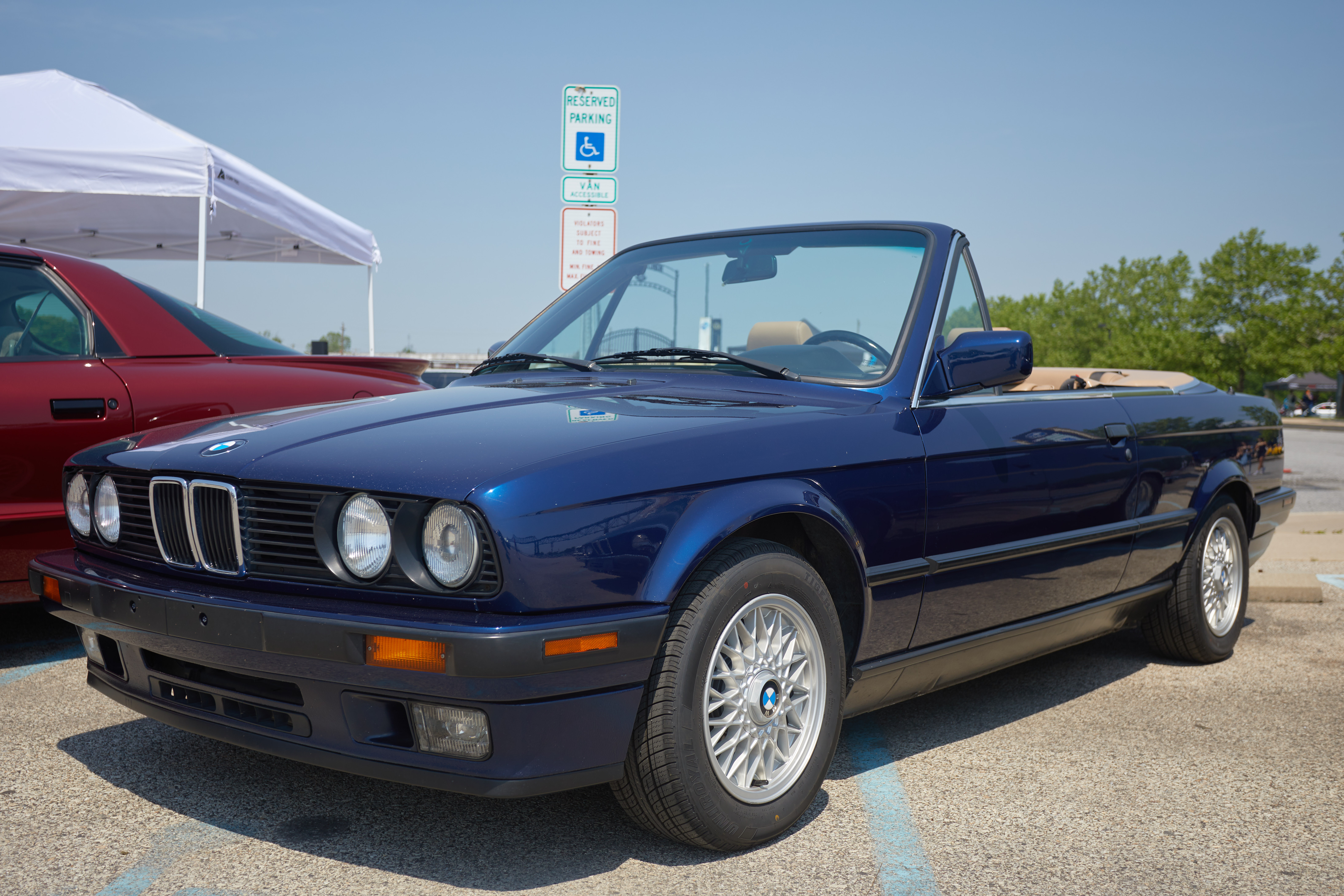 Blue BMW 325i convertible in parking lot.