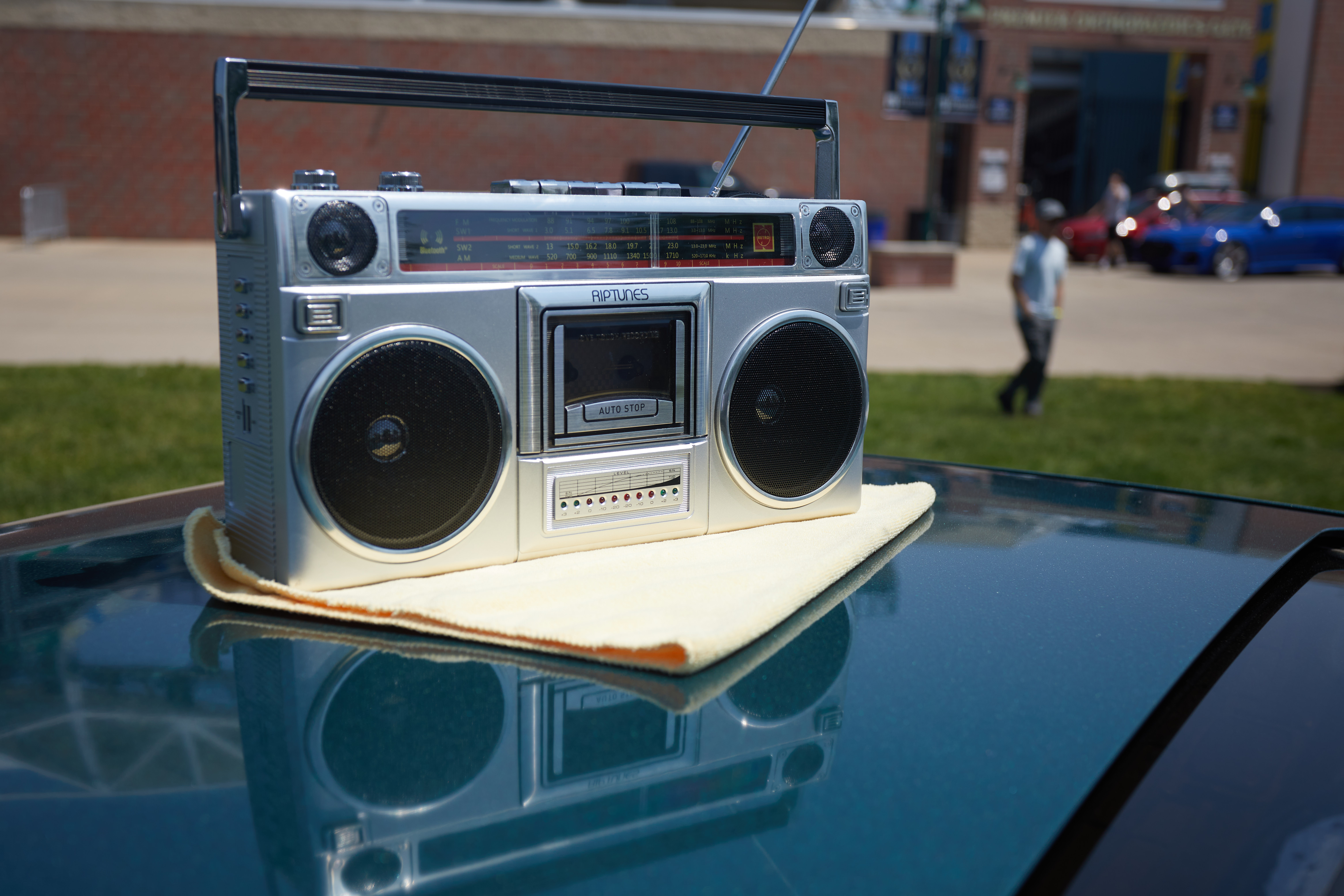 AM/FM tape boombox on roof of car.