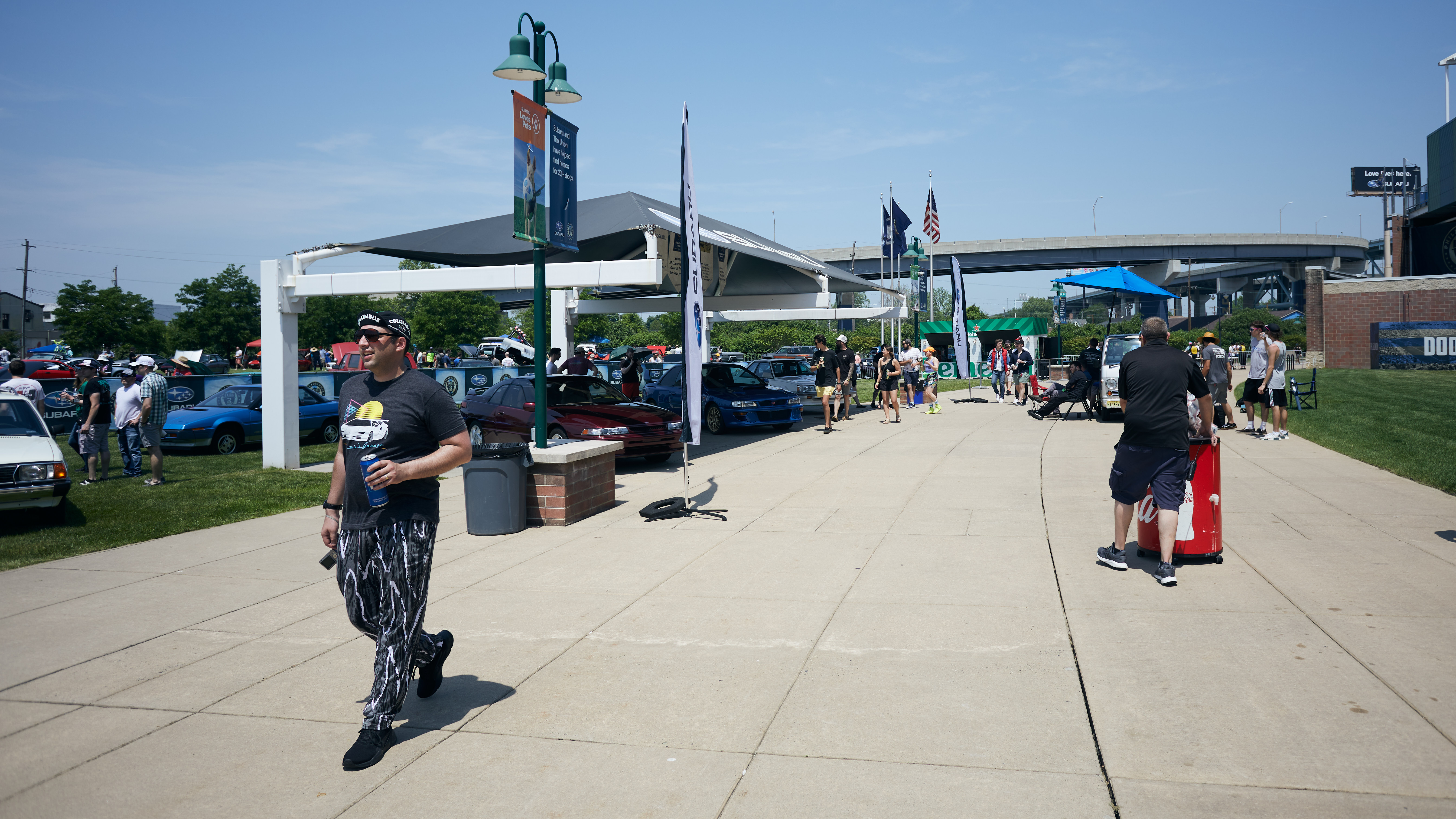 Subaru booth on left, with man dressed in 80s attire in foreground.
