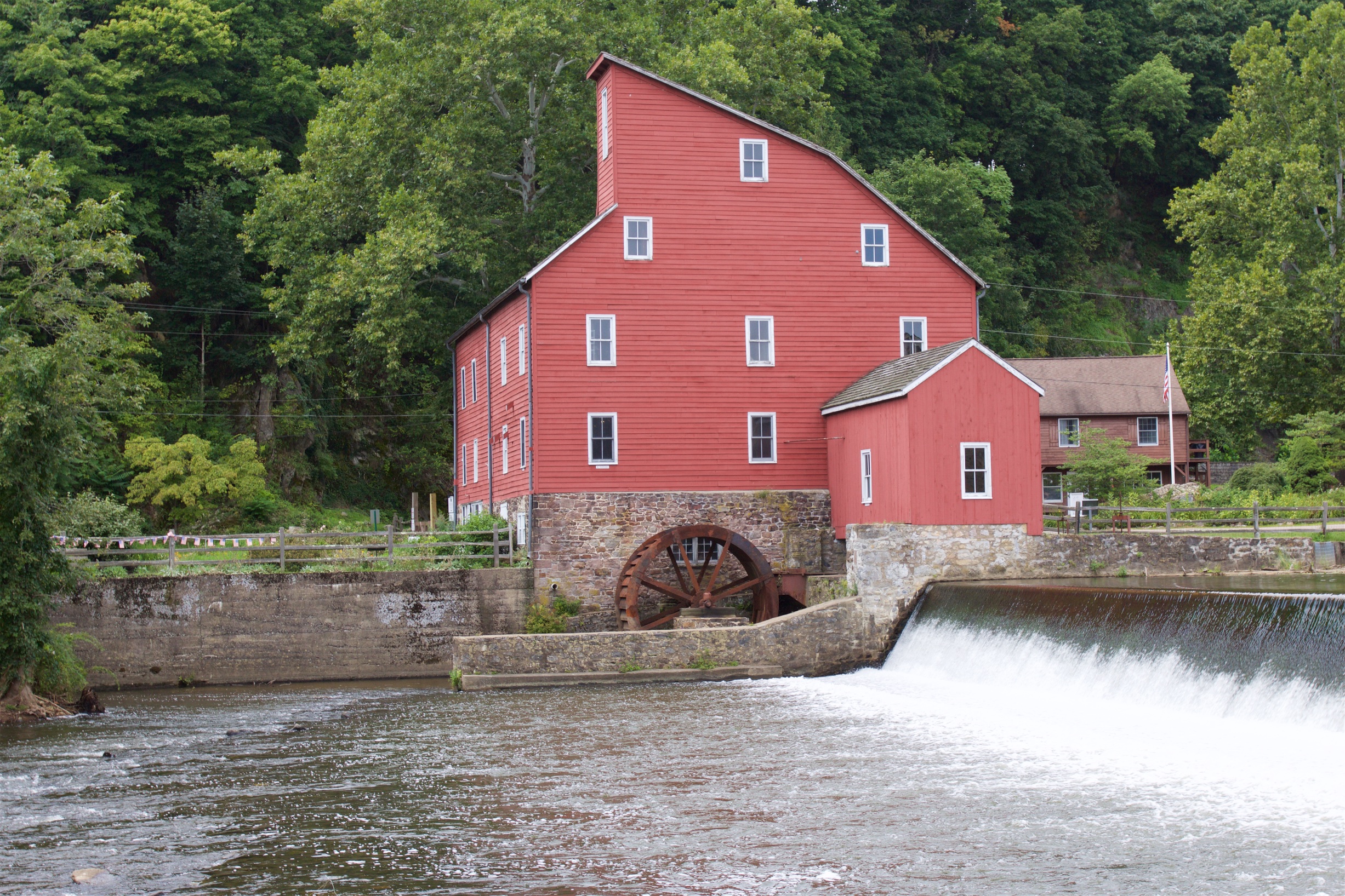 Red mill building along river.