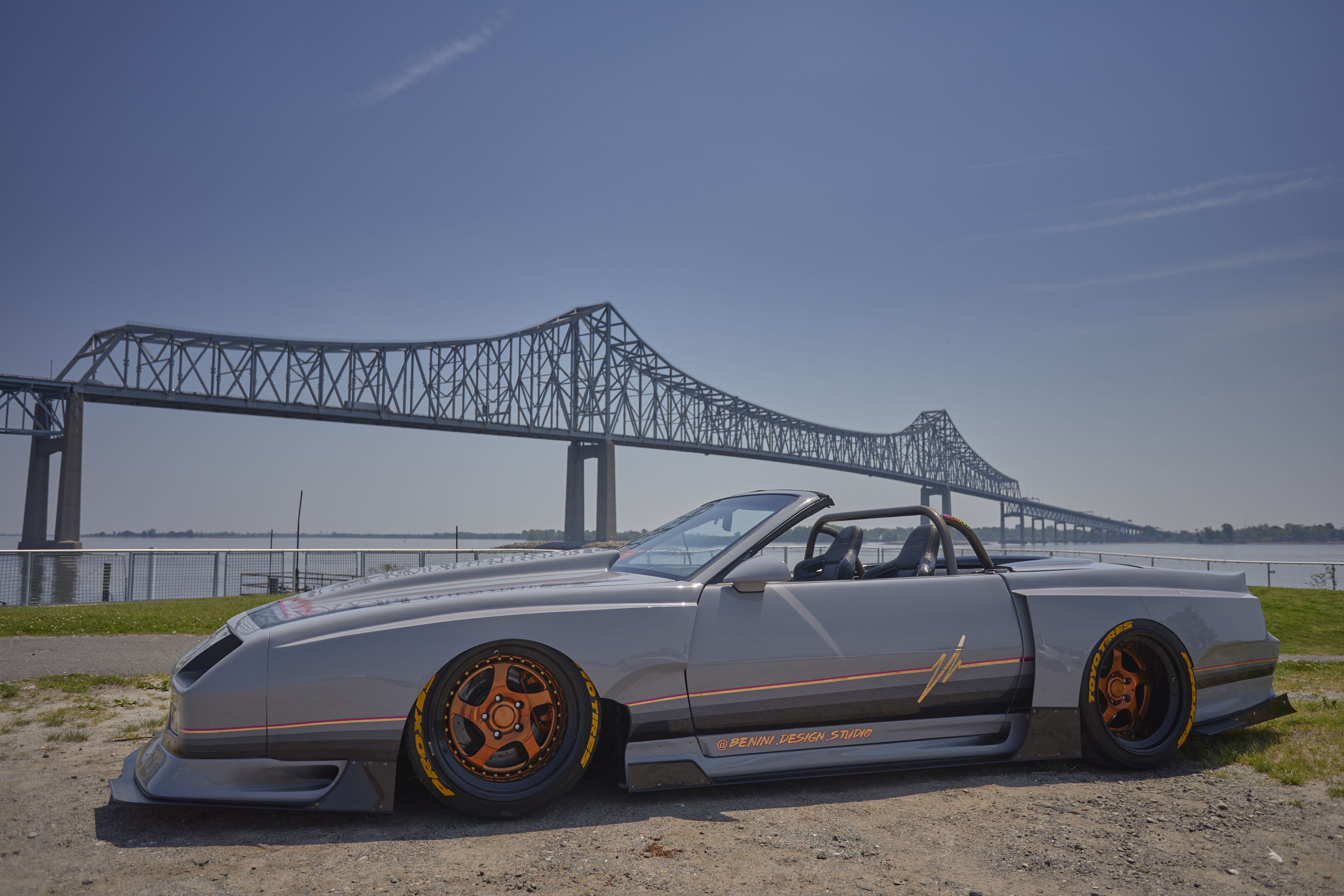 Chevrolet Camaro parked in front of Commodore Barry Bridge.