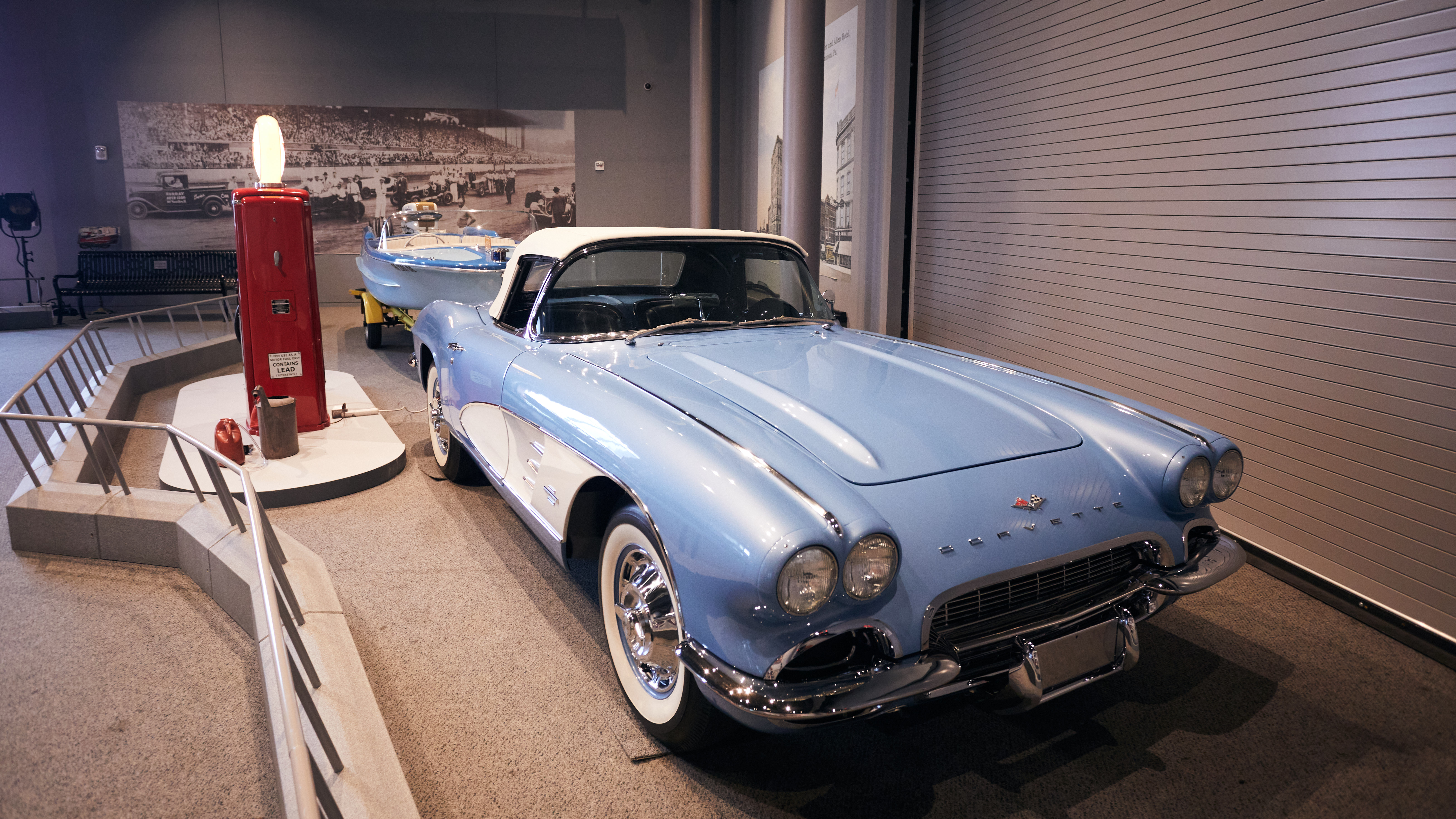 Blue 1961 Corvette pulling a small boat.