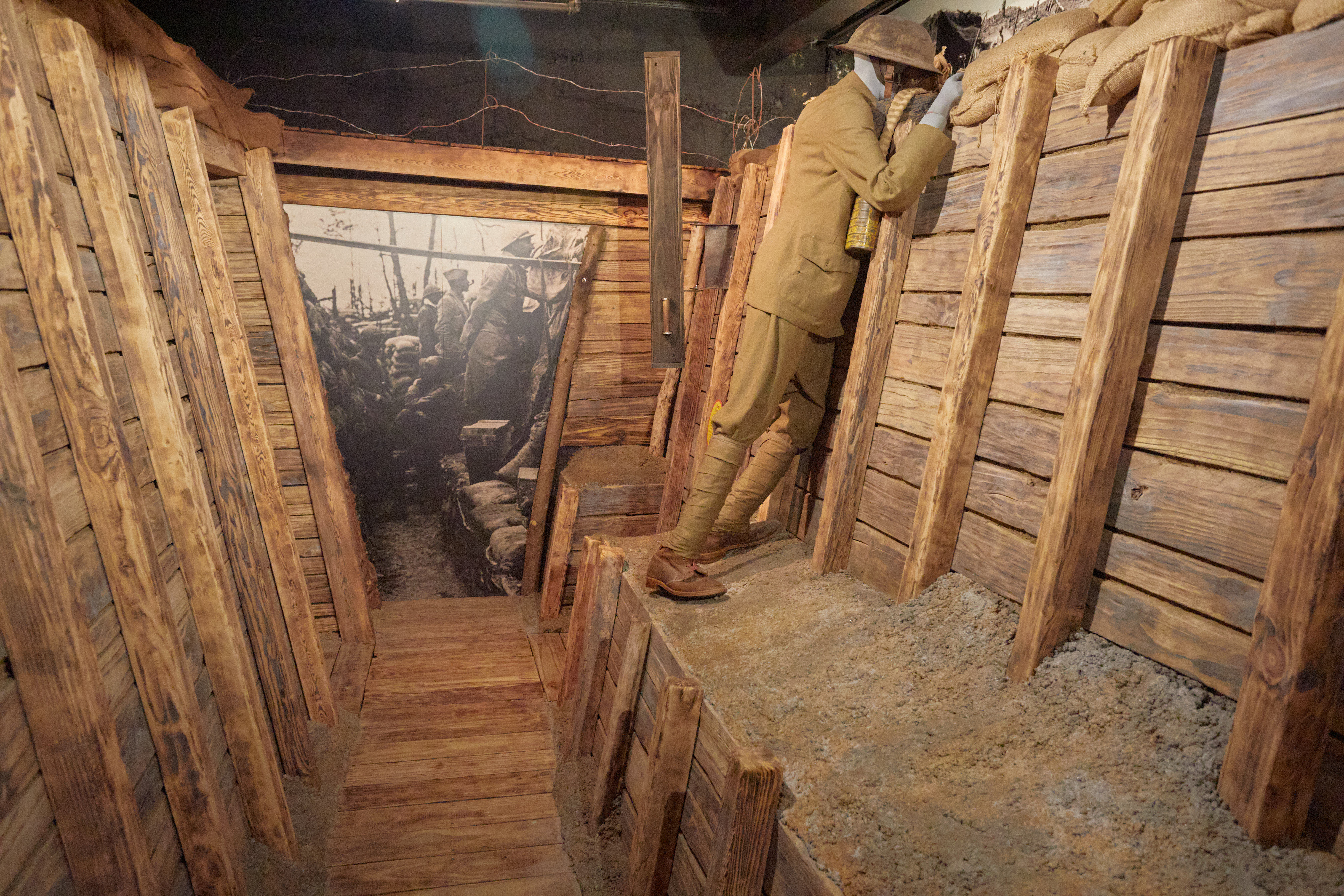 Replica of World War I fighting trench, with mannequin in observation position.