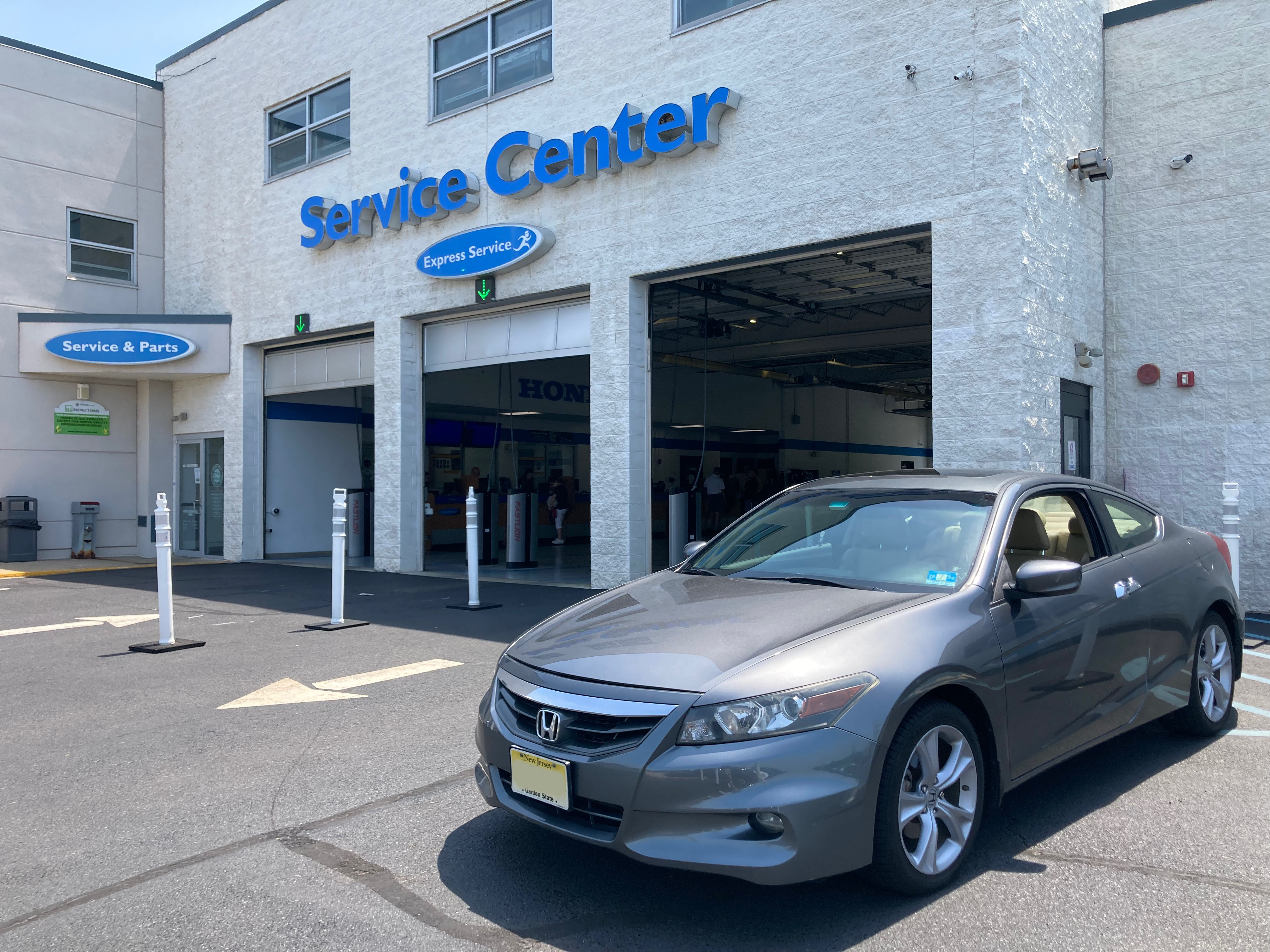 2012 Honda Accord parked in front of service center doors at dealership.