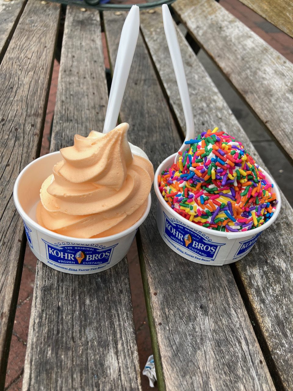 Two cups of ice cream in paper Kohr Bros cups.