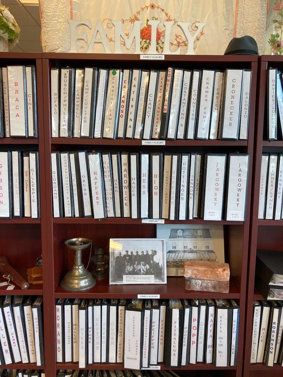 Bookcases with binders with family's names on them.