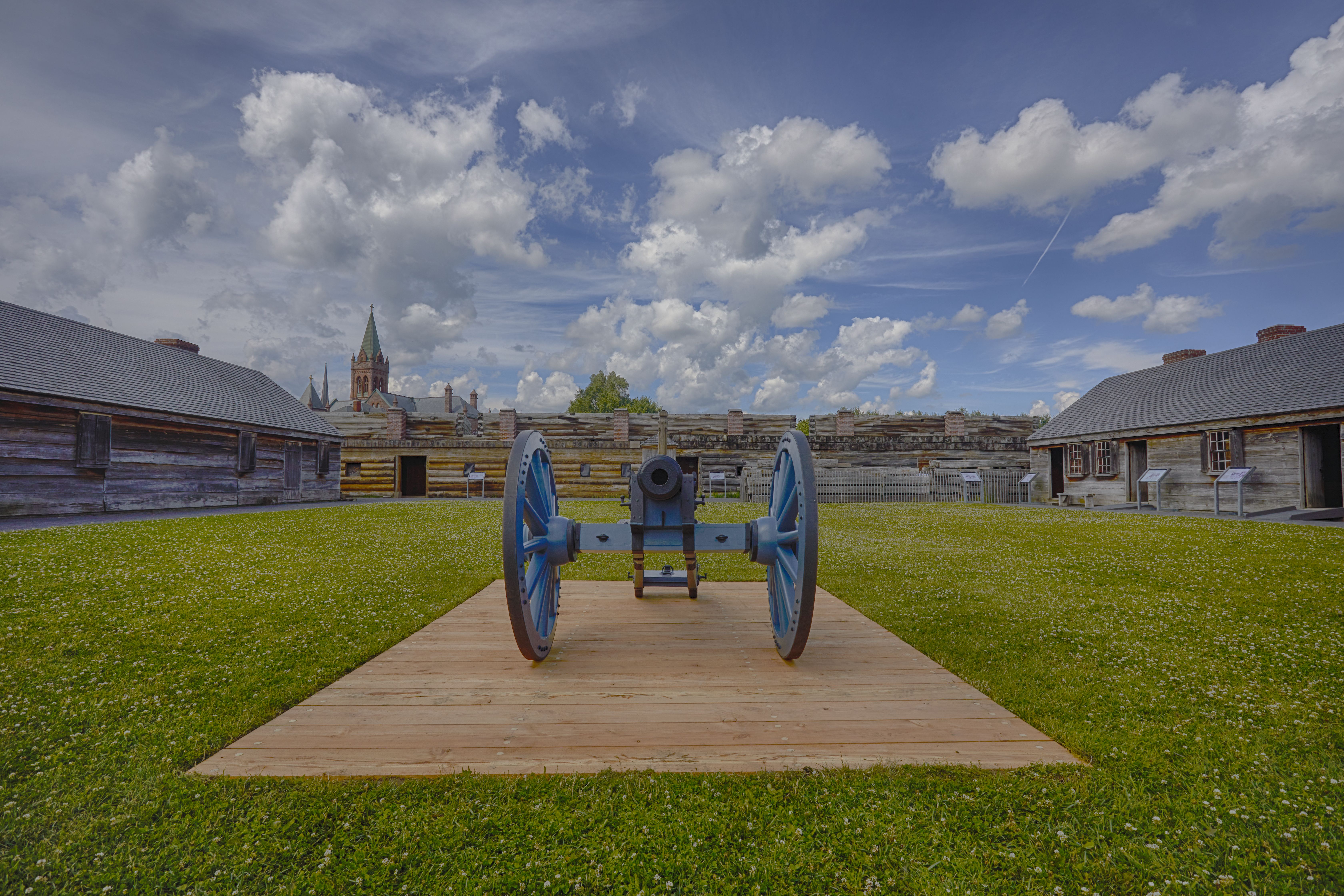 Cannon on parade ground of Fort Stanwix, with buildings around perimeter.
