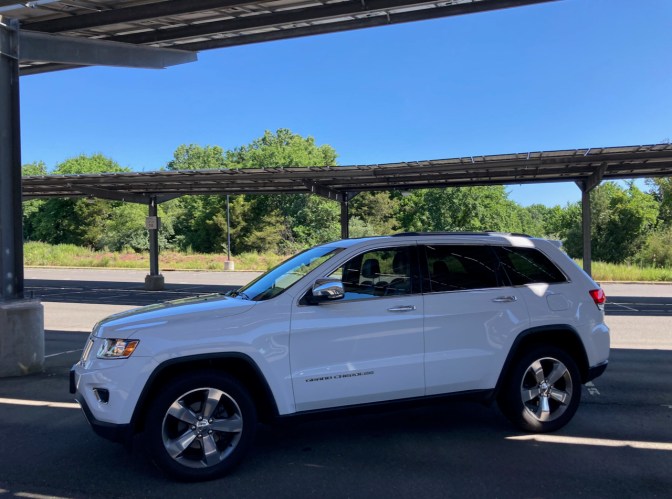 2014 Jeep Grand Cherokee parked beneath covered solar panels.