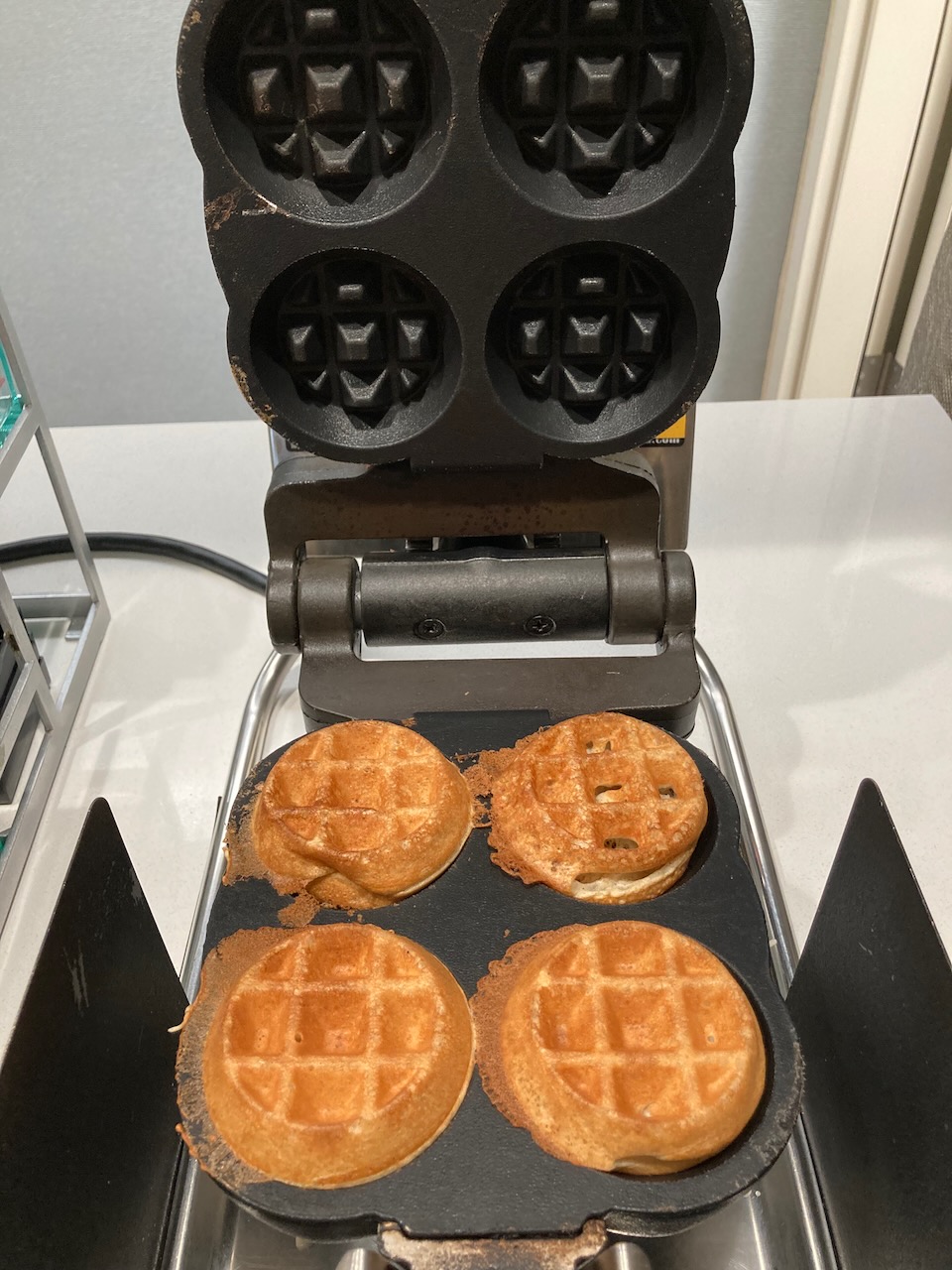 Four mini waffles in waffle maker.