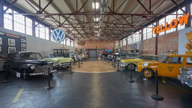 Collection of classic cars in a warehouse.