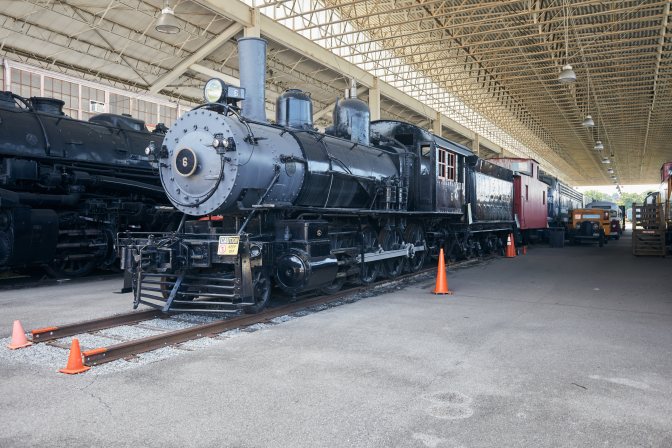 Two steam locomotives under steel canopy.