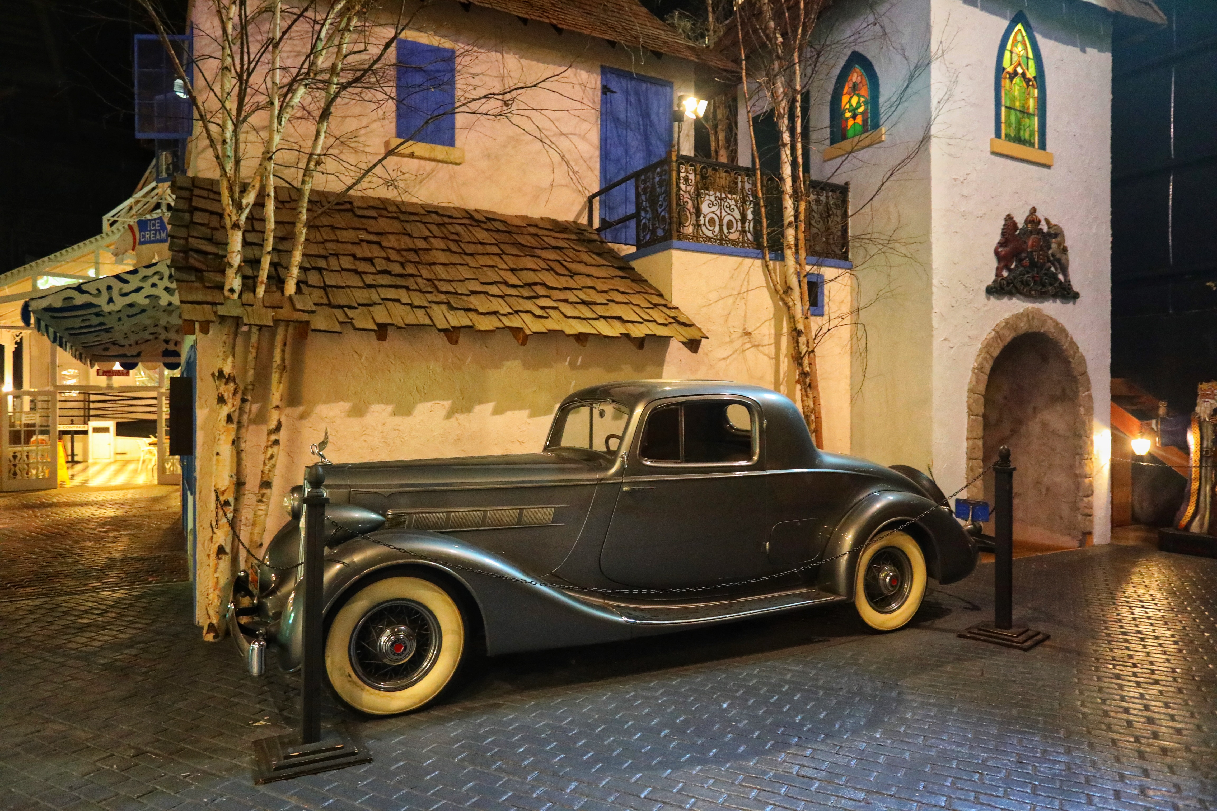 Classic car in front of European-style house.
