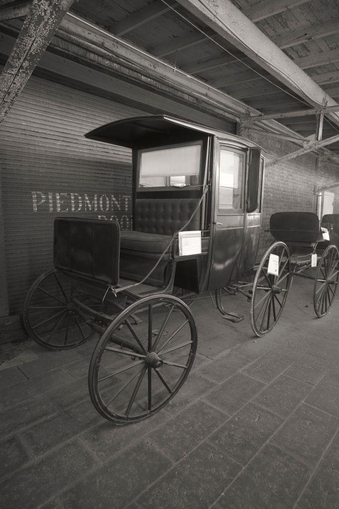 Horse-drawn carriage beside railway station.