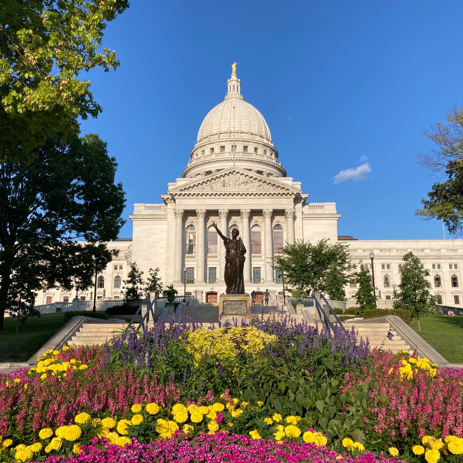 Wisconsin State House, with flowers and statue in foreground.
