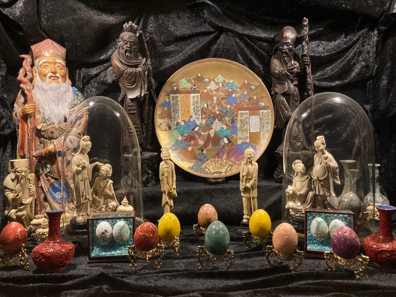 Collection of ceramic eggs and Chinese figurines.