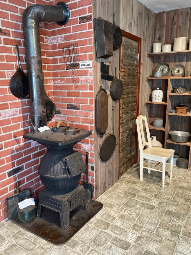 Pot-belly stove and kitchen items on display in replica 19th century kitchen.