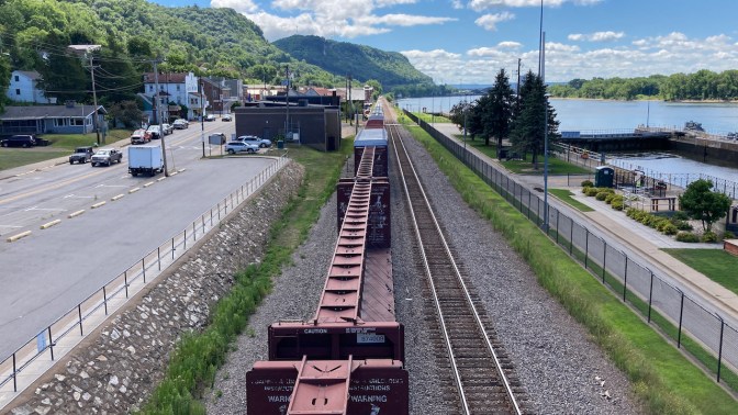 View of Alma, Wisconsin, with train running parallel to the river.