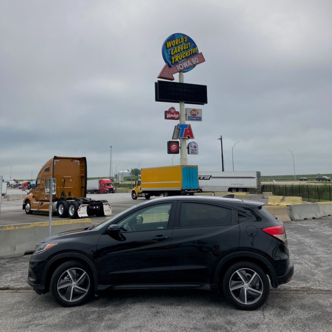 2021 Honda HR-V in front of sign for WORLD'S LARGEST TRUCKSTOP IOWA 80