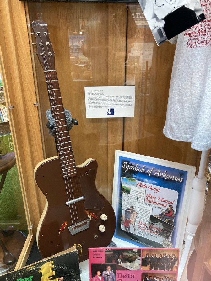 Glass display case with history of Delta Blues, an electric guitar, and other memorabilia.