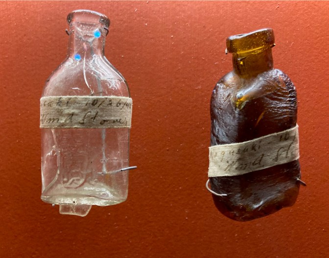 Two misshapen bottles on a red background.