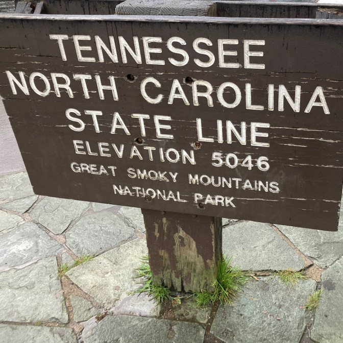 Sign that says TENNESSEE NORTH CAROLINA STATE LINE ELEVATION 5046 GREAT SMOKY MOUNTAINS NATIONAL PARK.