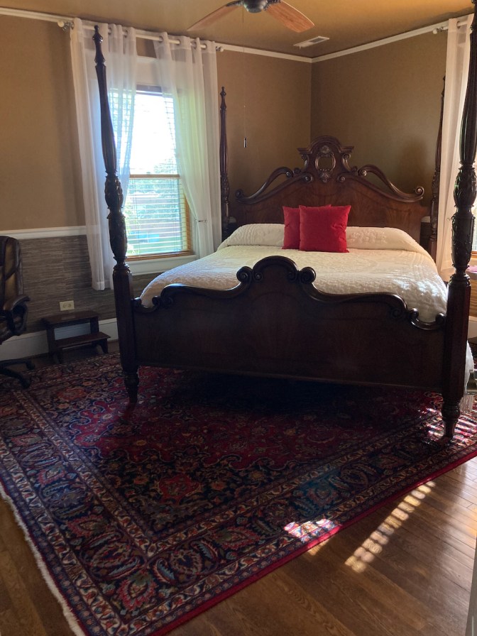 Four-poster king-sized bed in room.