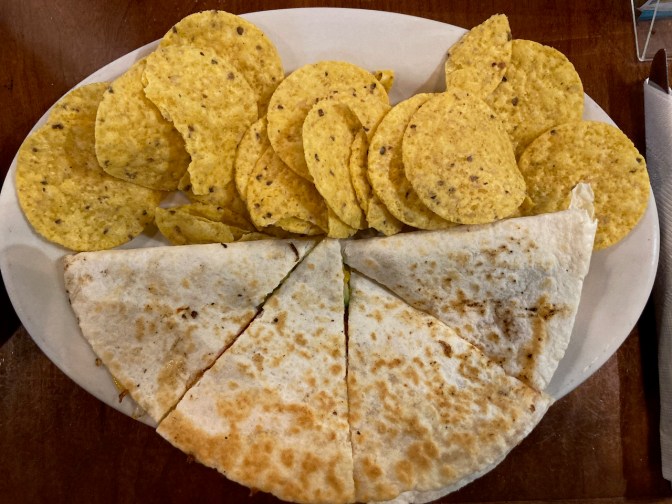 Quesadilla and chips on plate.