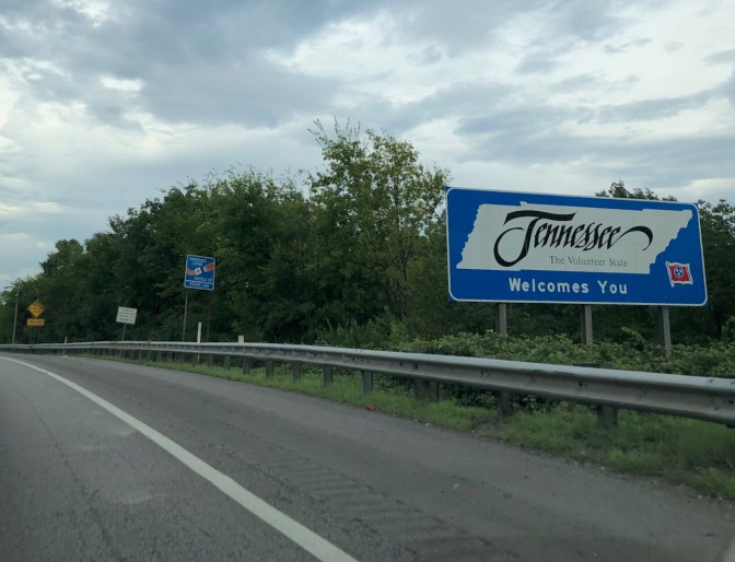 Highway with sign beside road that says TENNESSEE THE VOLUNTEER STATE WELCOMES YOU.