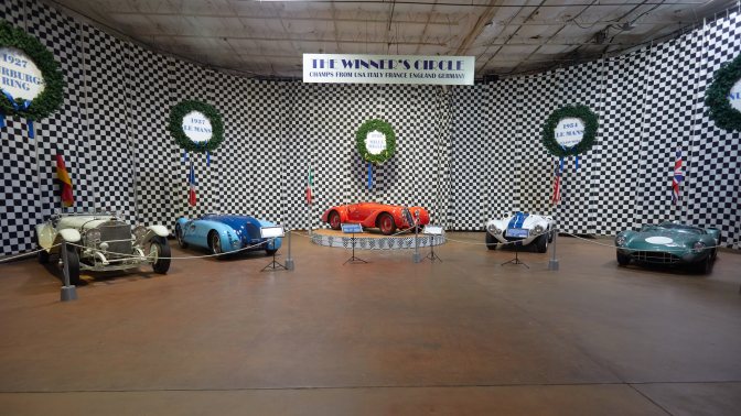 Winners Circle, with race winning cars on display.