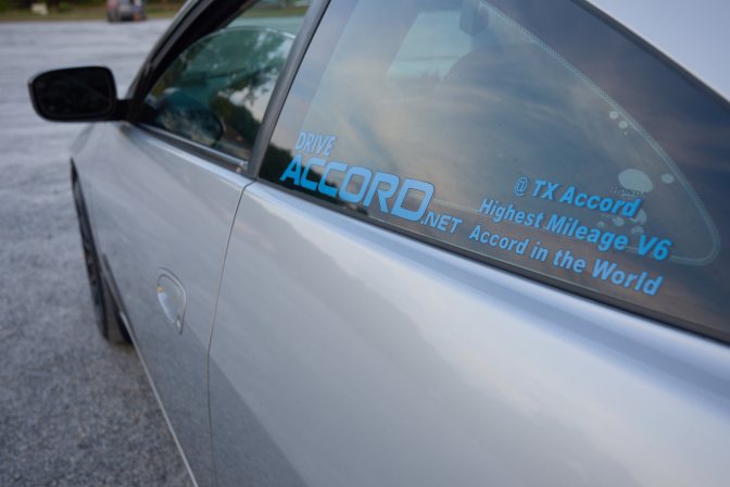 Side of 2003 Honda Accord coupe with window sticker that reads DRIVEACCORD.NET @TXACCORD HIGHEST MILEAGE V6 ACCORD IN THE WORLD.