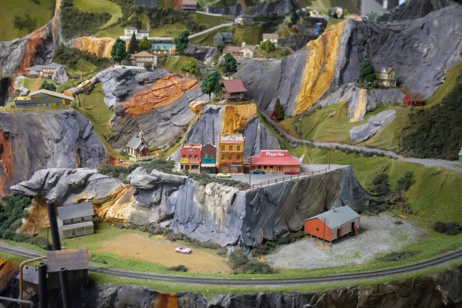 Model village with model train track running through it.