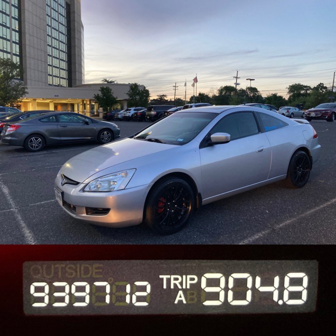 2003 Honda Accord coupe, in silver, parked in front of hotel. On bottom of image is photo of odometer - 939712 miles.