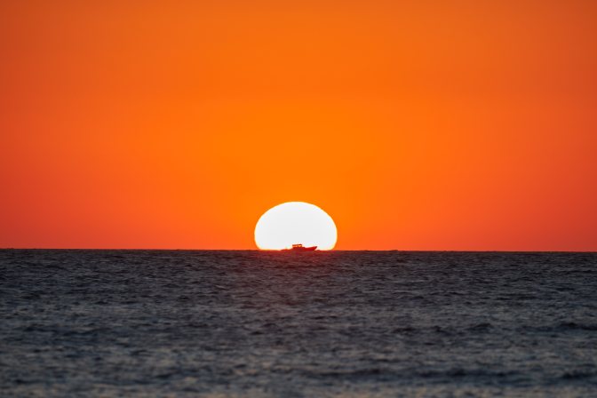Ship in front of sunset.