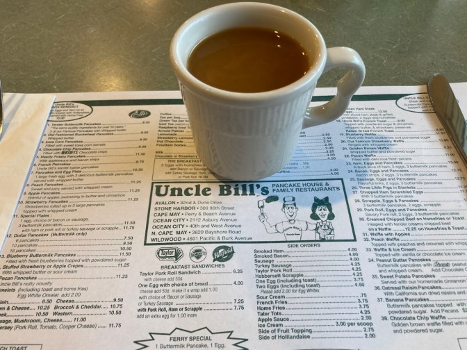 Coffee cup with coffee on top of menu for Uncle Bill's Pancake House.
