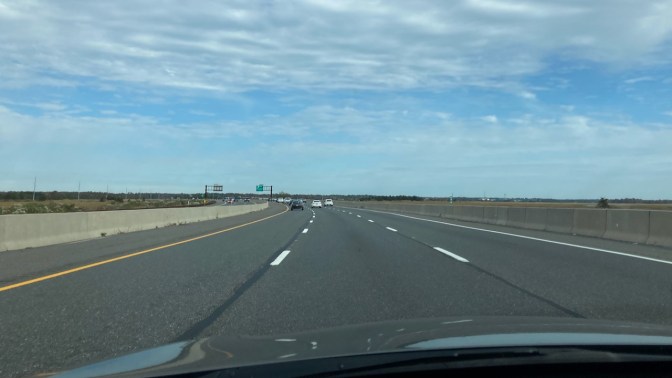 View of Garden State Parkway heading northbound on a sunny day with some clouds.