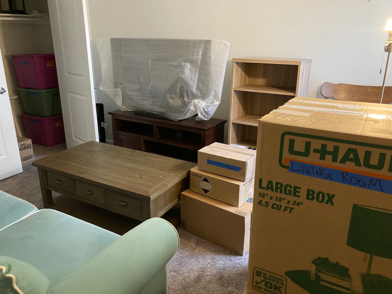 Packed boxes, along with furniture, in living room.
