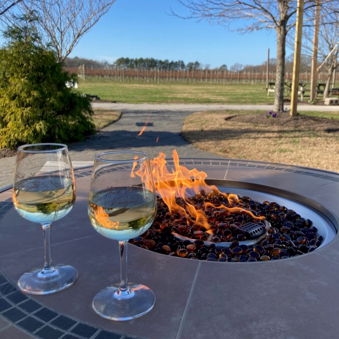 Two glasses of wine on fire pit.