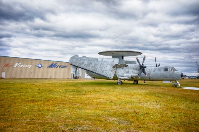 E-2 Hawkeye on lawn outside museum. Building in background with words AIR VICTORY MUSEUM is visible.