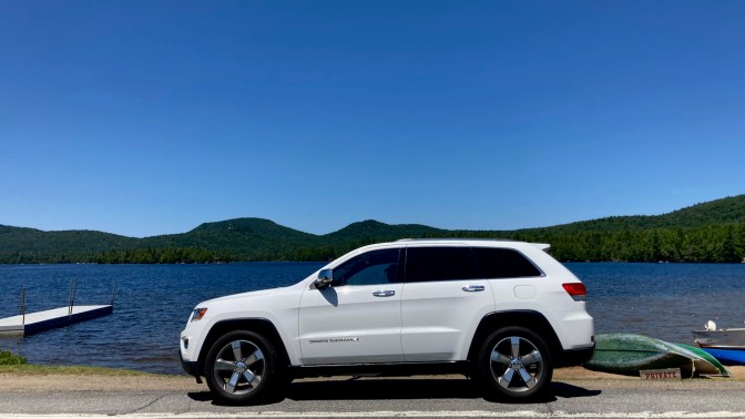 2014 Jeep Grand Cherokee parked in front of Blue Mountain Lake.