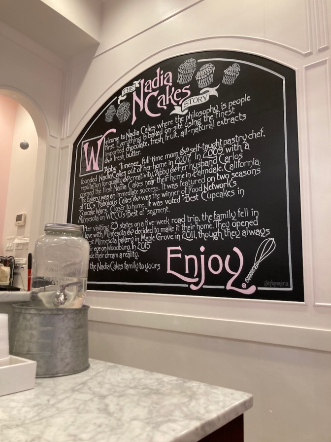 Chalkboard in cafe telling story of Nadia Cakes.