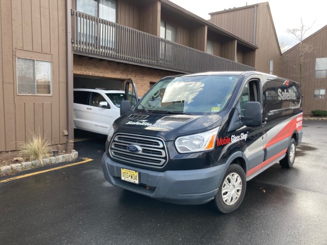 Safelite van, parked beside 2014 Jeep Grand Cherokee.