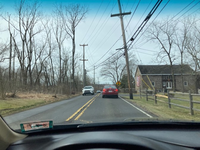 Two-lane country road through rural Pennsylvania. A stone barn is on the right side of the road.
